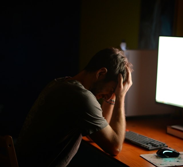 Man with co-occurring porn addiction and depression looking upset while sitting in front of a computer