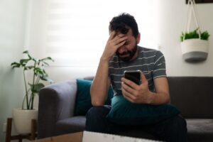 Man looking at phone wondering how does porn affect the brain.